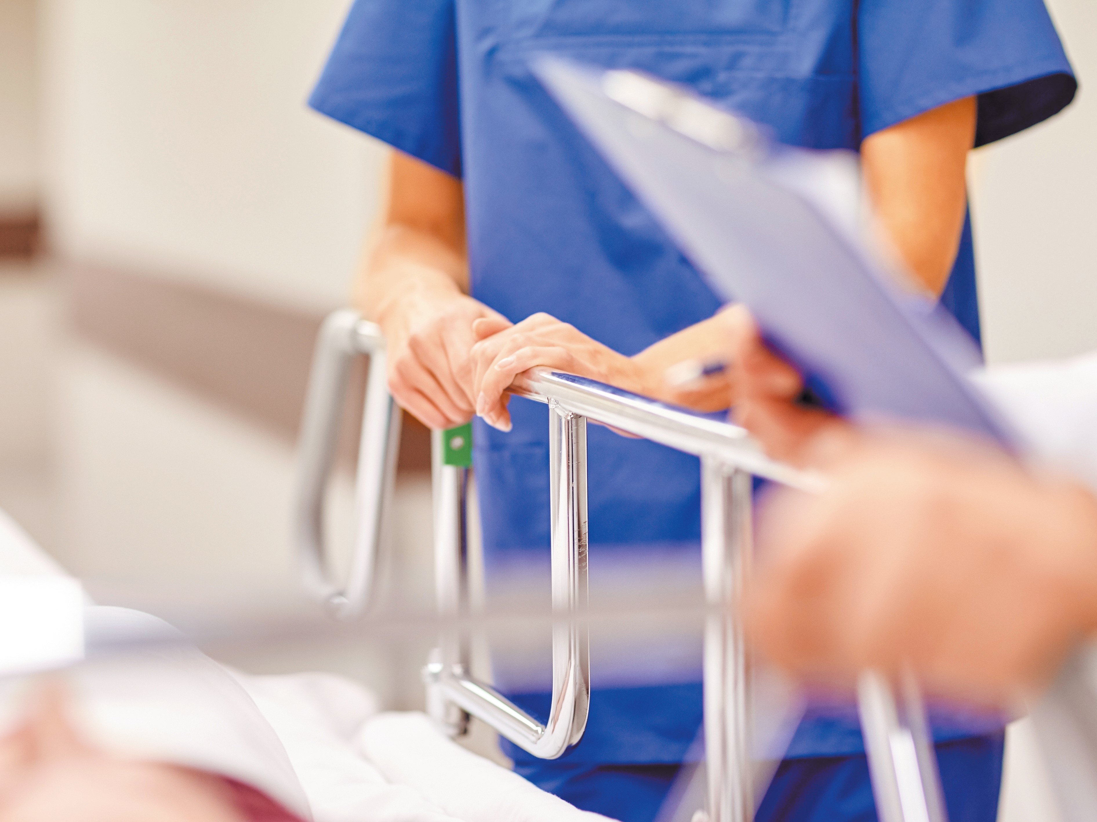 Healthcare professionals standing next to hospital bed